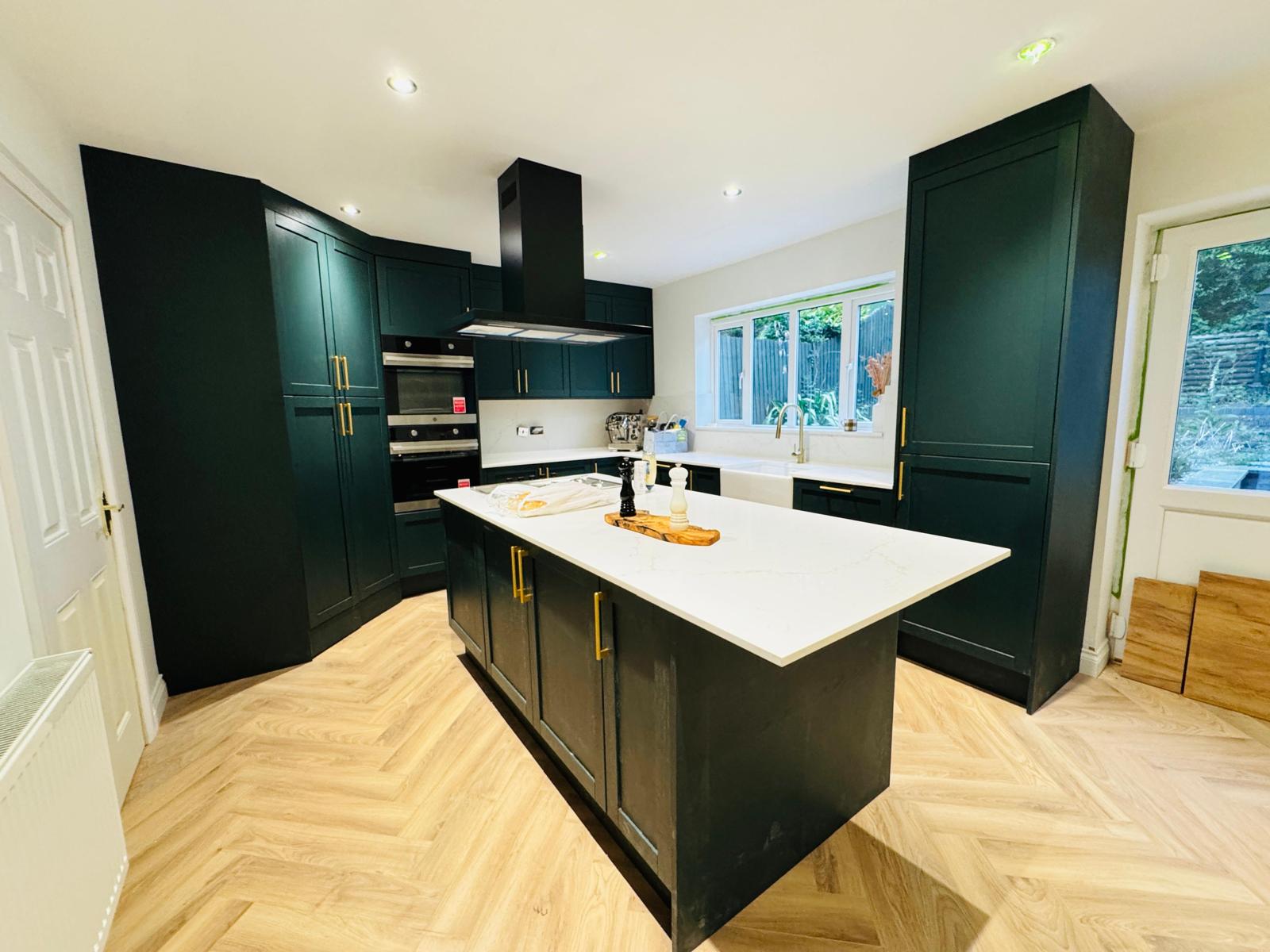 Dark green shaker kitchen island with quartz worktop