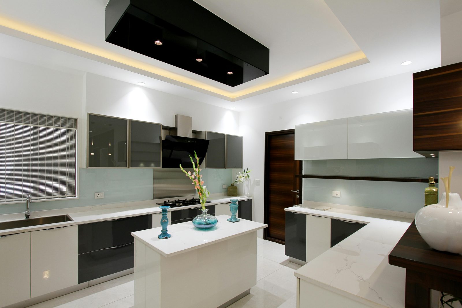 Wide modern kitchen with grey gloss uppers and a quartz-topped island